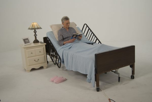 women in hospital bed at home reading a book