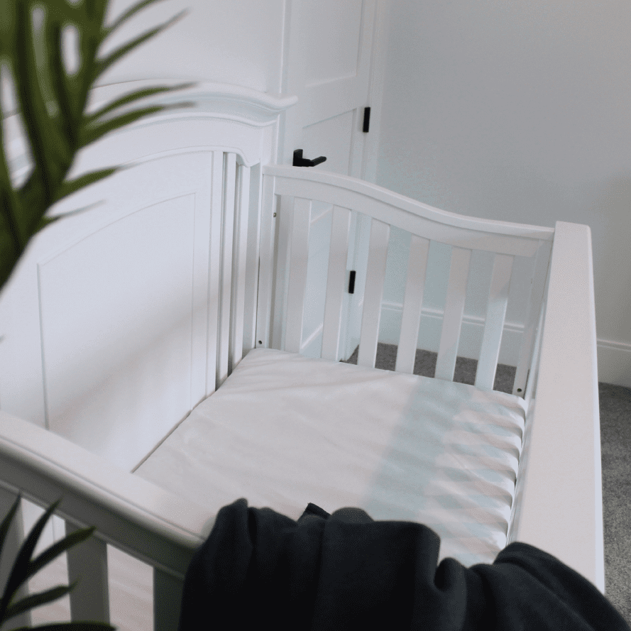 SaniSnooze Waterproof Crib Mattress in a white crib
